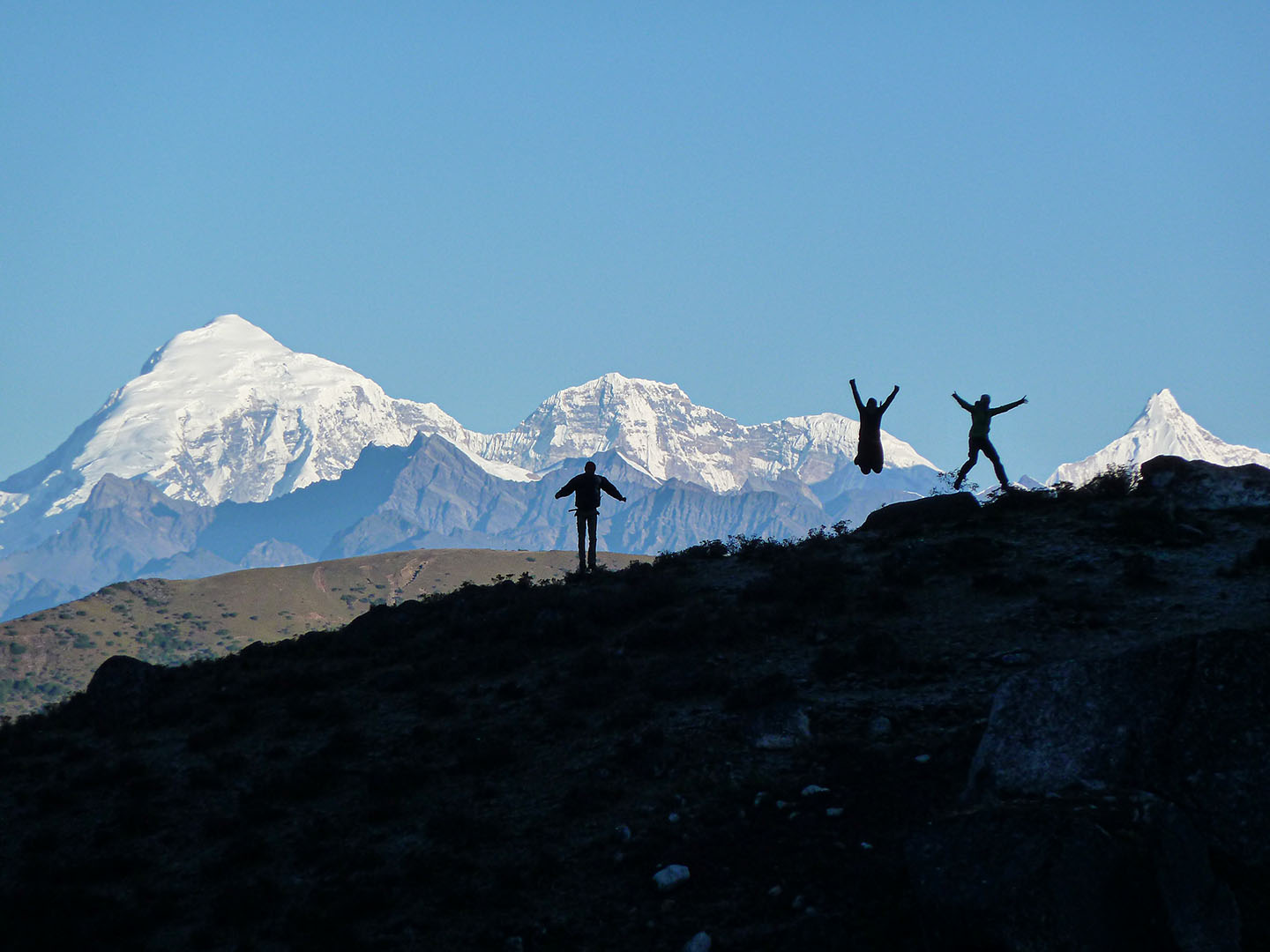 3 trekkers jumping on the mountain infront of the mighty Jomolhari