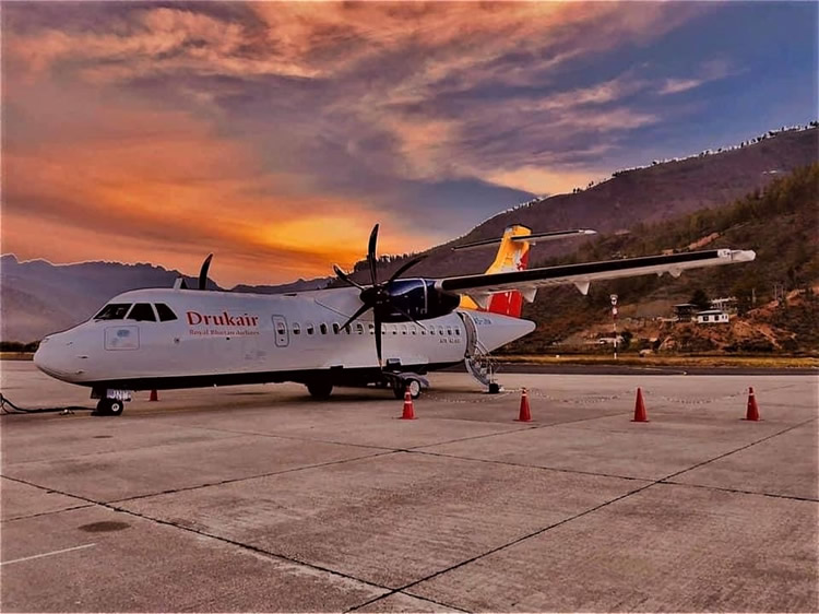 Trip to Bhutan from Australia. Drukair airplane with dragon logo flying over the Himalayas.